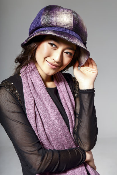亚洲女孩戴着冬季羊毛帽，在灰色的背景上拍了一张大照片图片下载
