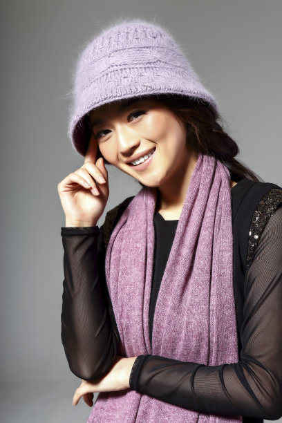 亚洲女孩戴着冬季羊毛帽，在灰色的背景上拍了一张大照片图片下载