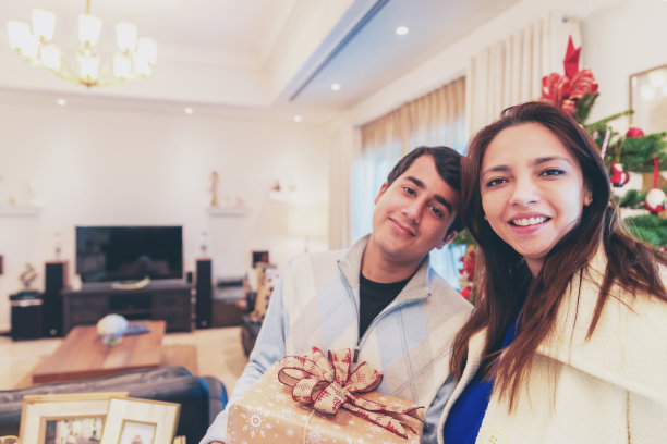 圣诞树旁的成年儿子和母亲肖像图片下载
