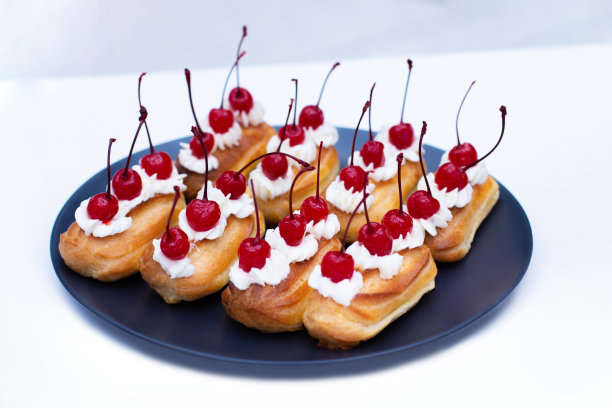 奶油樱桃果。装盘甜点，法式奶油泡芙蛋糕和鸡尾酒樱桃图片下载