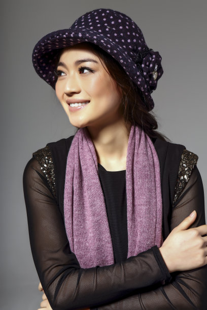 亚洲女孩戴着冬季羊毛帽，在灰色的背景上拍了一张大照片图片下载