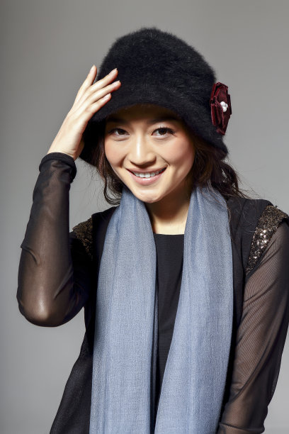 亚洲女孩戴着冬季羊毛帽，在灰色的背景上拍了一张大照片图片下载