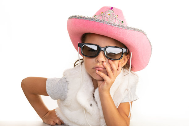 带着牛仔帽和太阳镜的沉思的小女孩图片下载