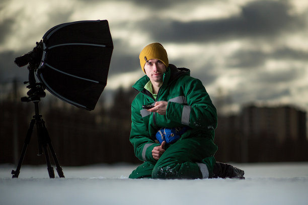 摄影师在草地上远程拍摄自动画像。在外面。图片下载