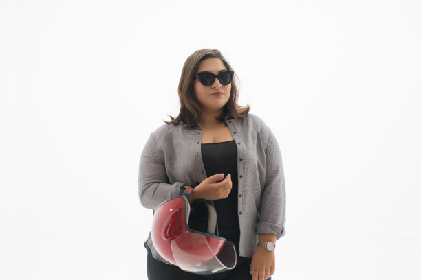 年轻貌美的超重女人拿着头盔图片下载