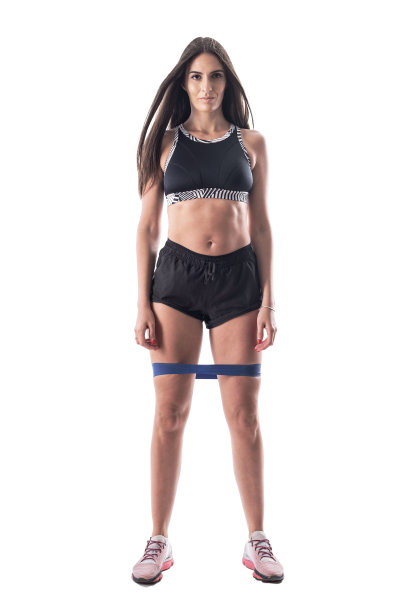 骄傲的运动体操女孩在顶部和短裤与阻力带腿。图片下载