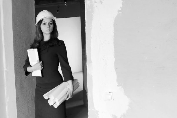 一名女建筑师在工地上的黑白照片，带着图纸和笔记本图片下载