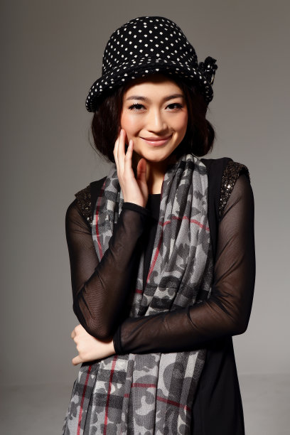 亚洲女孩戴着冬季羊毛帽，在灰色的背景上拍了一张大照片图片下载