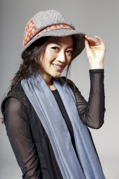 亚洲女孩戴着冬季羊毛帽，在灰色的背景上拍了一张大照片图片下载