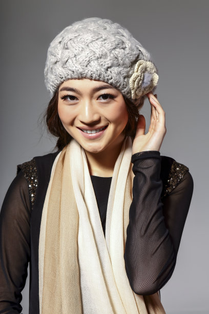 亚洲女孩戴着冬季羊毛帽，在灰色的背景上拍了一张大照片图片下载