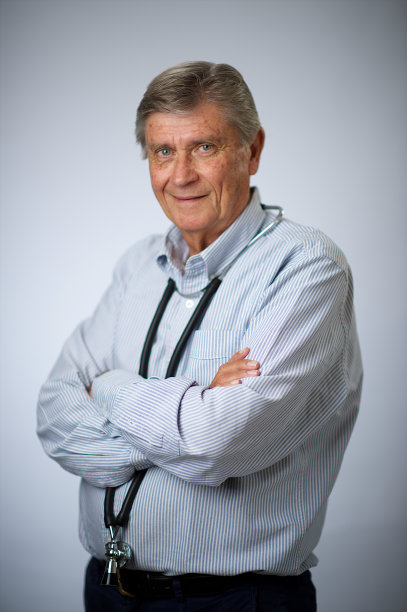 经验丰富的男资深医生腰上肖像与听诊器双臂交叉微笑图片下载