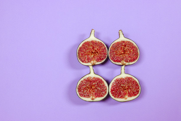 新鲜成熟的无花果紫色背景与文字空间。食物的照片。副本的空间。有红色种子的紫色无花果。平躺，俯视图。食品的概念图片下载