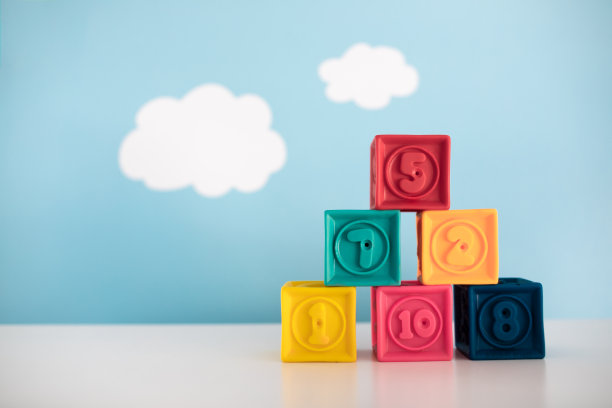 五彩缤纷的玩具积木互相堆叠，映衬着云天的背景。图片下载