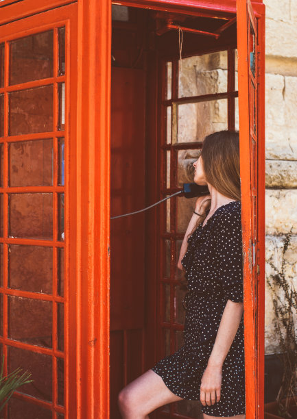 年轻女子在电话亭里打电话图片下载