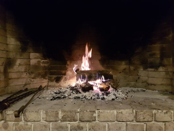 在石头壁炉里燃烧着壁炉。舒适的冬天的概念。图片下载