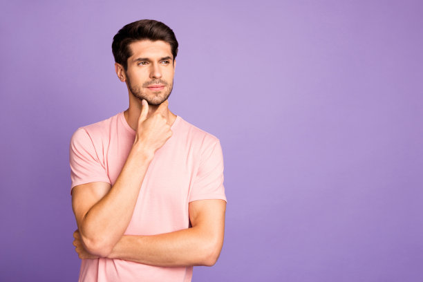 他的肖像，他漂亮迷人的集中思想深色胡子的家伙穿着粉红色t恤创造新的想法触摸下巴孤立在紫罗兰紫色淡紫色柔和的颜色背景图片下载