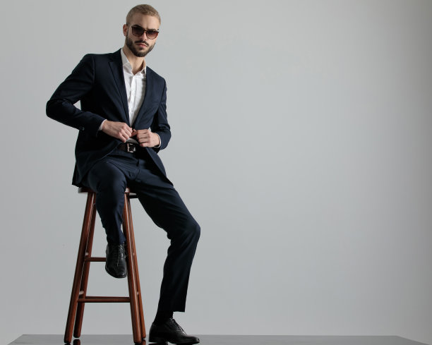 商人坐着，严肃地拿着夹克上的纽扣图片下载