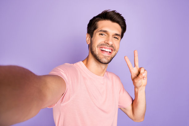 他的自画像他漂亮迷人可爱愉快的胡子深色的家伙穿着粉红色t恤显示v符号孤立在紫罗兰紫色淡紫色柔和的颜色背景图片下载