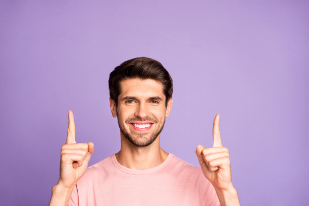 他的特写肖像，他漂亮迷人，愉快愉快的内容蓄着胡子的深色的家伙穿着粉红色t恤指着两个手指向上跟着像孤立的紫色紫色淡紫色柔和的颜色背景图片下载