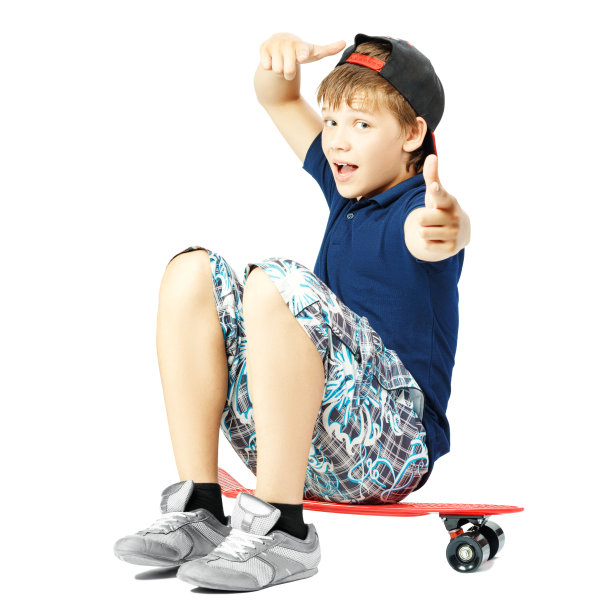 少年用滑稽的表情用手比划着脸，坐在滑板上图片下载