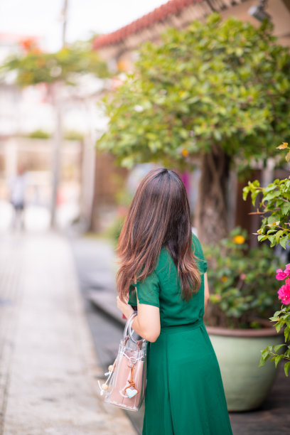 后视图的年轻女子走在街上图片下载