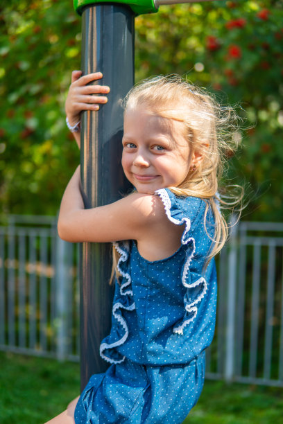 一个被绑在单杠上的女孩在操场上玩杆子图片下载