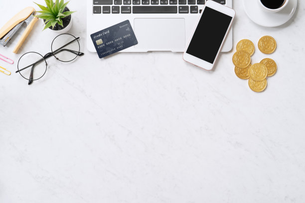 用信用卡在线支付的概念与智能手机，笔记本电脑上的办公桌上干净明亮的大理石桌子的背景。图片下载