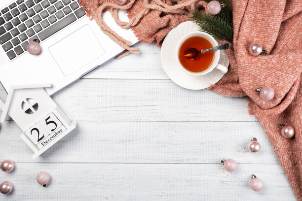 有粉色圣诞树装饰的工作空间，笔记本电脑，一杯茶图片下载