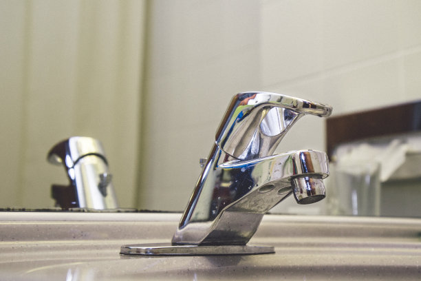 顶部特写，特写照片的钢金属水龙头阀门控制手柄在浴室。旧的使用图像和蓝色滴蓝色和红色的指示。复制粘贴“t”r“n图片下载