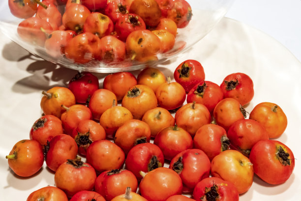 靠近山楂水果在盘子上的白色背景。图片下载