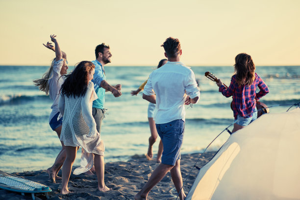 快乐的朋友们在海滩上弹着吉他，一起唱着歌图片下载