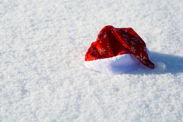红色圣诞老人的帽子在雪的背景。圣诞节和新年假期庆祝概念。前视图图片下载