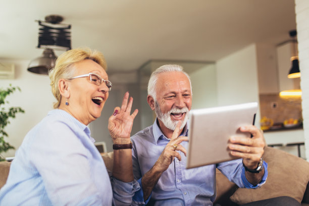 一对聋哑老年夫妇在数码平板电脑的摄像头上用手语交谈图片下载