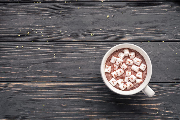 可可巧克力杯，热饮料和白色棉花糖放在舒适的木质桌子上，可可杯放在棕色木制质朴的桌子上，假日咖啡馆商店，上方俯视视图，复制空间图片下载