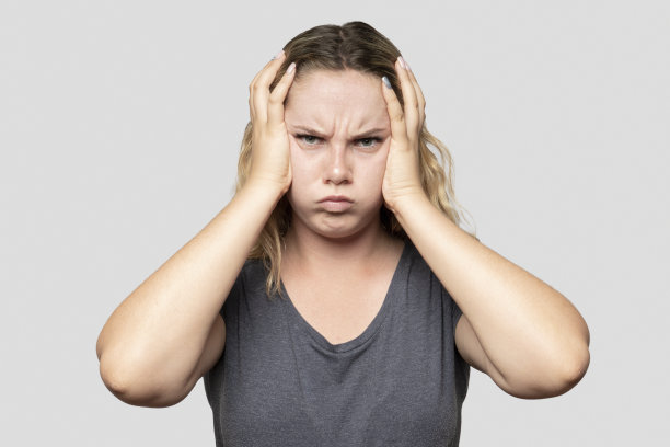 灰色背景下沮丧的年轻女子的肖像图片下载