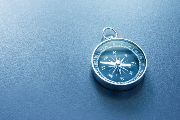 指南针放在一张蓝色的办公桌上。商业和创意的概念图片下载