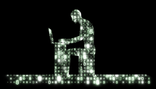 一个用笔记本电脑的男人的剪影。图片下载