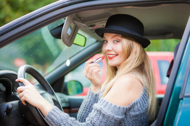 年轻女子在车里涂口红图片下载