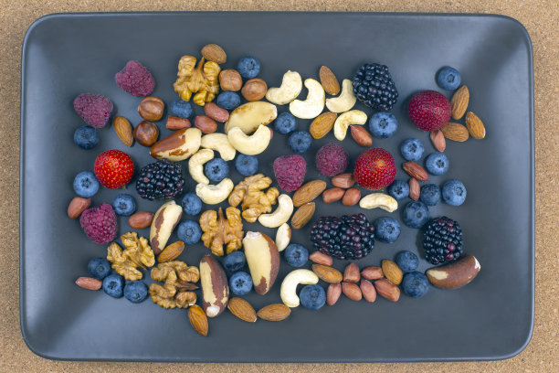 在盘子里放不同的浆果和坚果。维生素蛋白质和健康食品图片下载