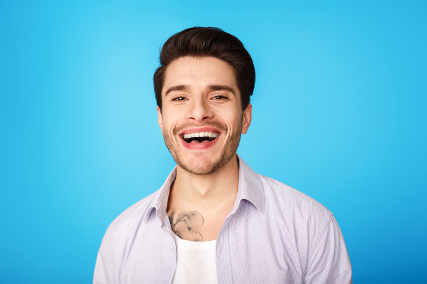 年轻微笑的男人在蓝色的工作室背景图片下载