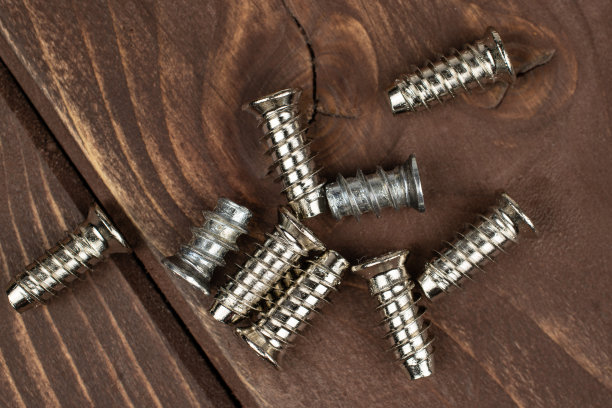 棕色木头上光滑的金属螺栓图片下载