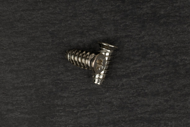 灰色石材上光滑的金属螺栓图片下载