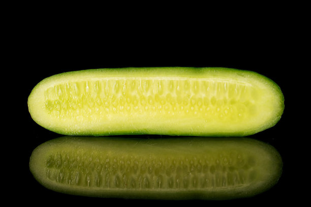 新鲜的小黄瓜，隔离在黑色玻璃上图片下载