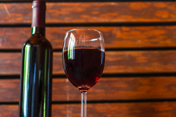 酒杯和酒瓶放在木桌上图片下载