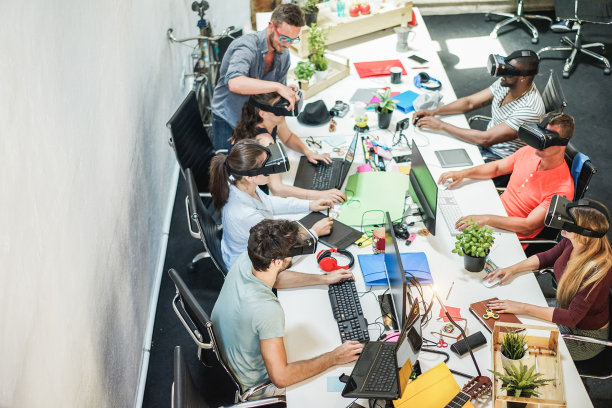 在创意办公室使用虚拟现实眼镜的年轻团队-同事在工作中尝试新的技术设备-商业，营销和技术趋势概念-专注于两个底层的家伙头戴图片下载