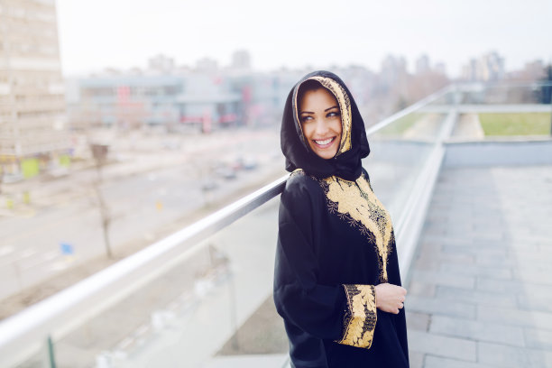 穿着传统服装站在屋顶上眺望远方的美丽穆斯林女人图片下载