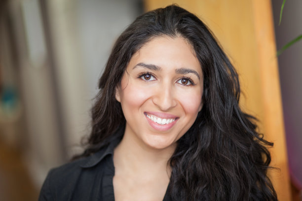 在办公室微笑的拉丁女人。她真的很高兴。图片下载