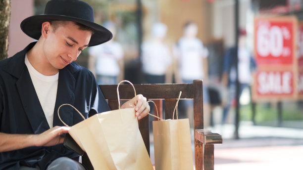 年轻人在看购物袋。图片下载