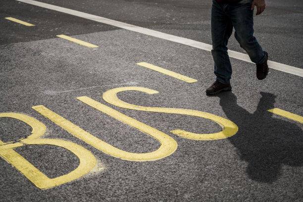 一个人正在过马路上的公交站牌图片下载