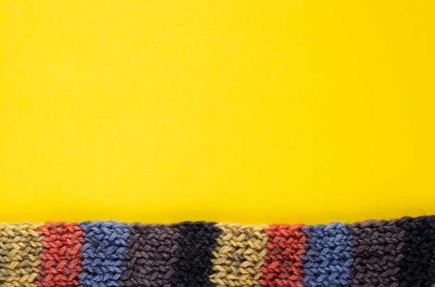 黄色背景上的羊毛围巾组成。平的。图片下载